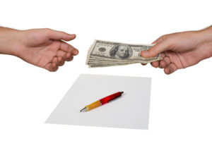 Image of hands exchanging money for a contract