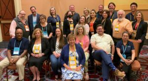 People standing in a group smiling for the camera with name badges on