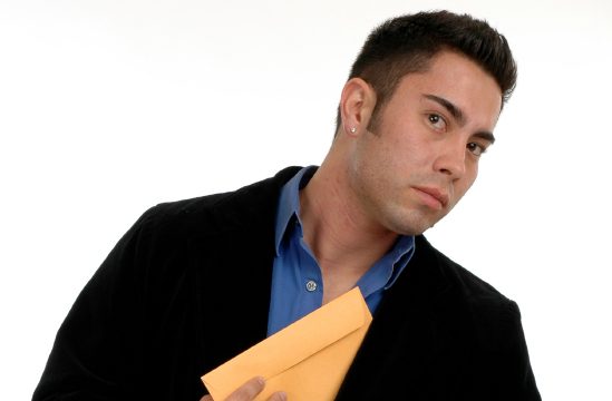 Image of a man slipping a manila envelope into his coat