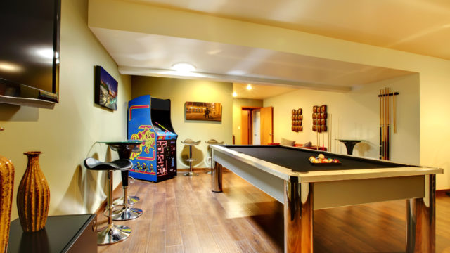 Clubhouse with a pool table, arcade game, stools and flat screen TV