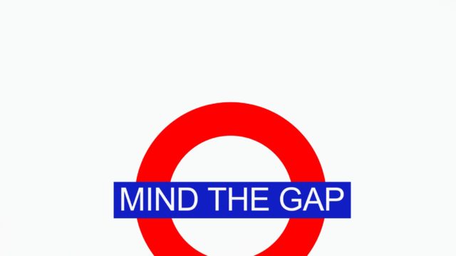 finger pointing to underground sign that reads Mind the Gap