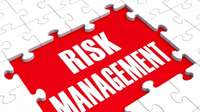 Risk Management in white letters on a red background surrounded by a white puzzle