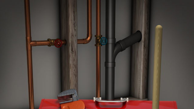 a red tool box near pipes with a plunger, wrench, a drain and some loose piping