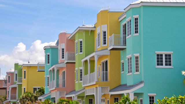 a row of townhome condominiums in turquoise, yellow, pea green and salmon colors
